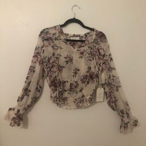 Sheer long sleeve top with purple floral pattern.